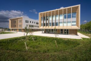 siège social avec une passerelle vitrée. Bâtiment sur pilotis.